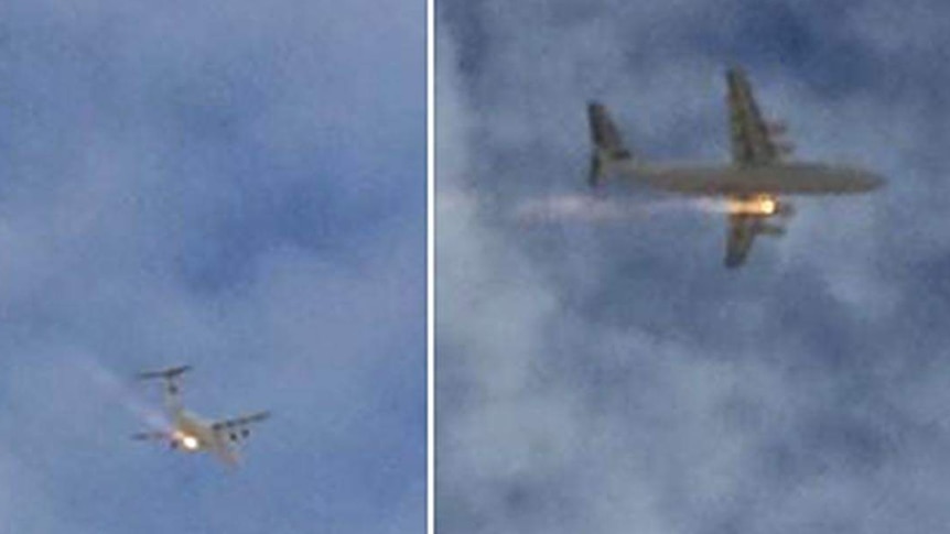 A plane with what looks to be flames coming from one of its engines flies over Perth.