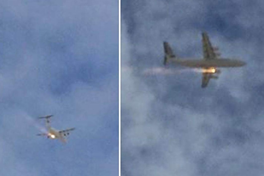 A plane with what looks to be flames coming from one of its engines flies over Perth.