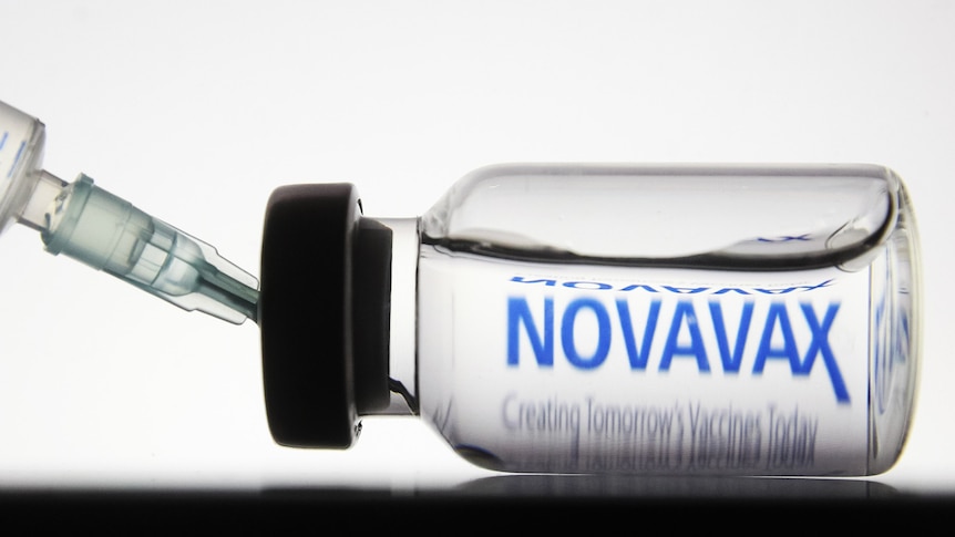 A syringe in a vial of Novavax COVID vaccine.