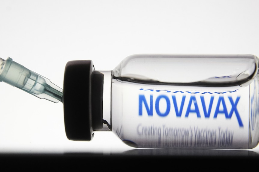A syringe in a vial of Novavax COVID vaccine.