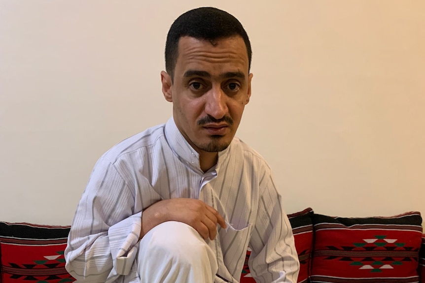 A man sitting on the ground with food prepared around him. 