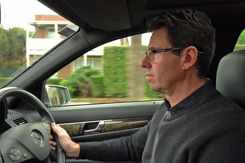 A man behind the wheel of a car.