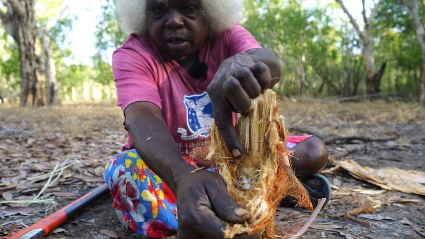 Aboriginal woman holds palm tree heart