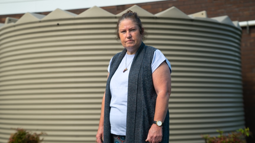 A woman looks at the camera with a concerned expression