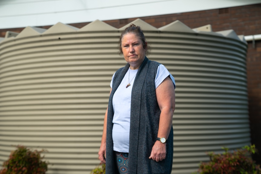 A woman looks at the camera with a concerned expression