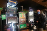 Peter Johnston standing in front of poker machines
