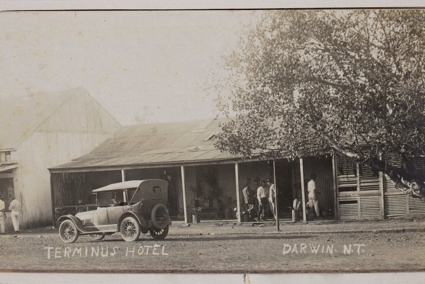 A historic black and white photo of the Terminus Hotel in Darwin, with people and a car seen out the front of the hotel.