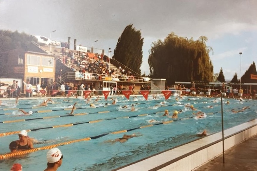 A 1980s colour photograph of a swimming carnival at the Glenorchy pool