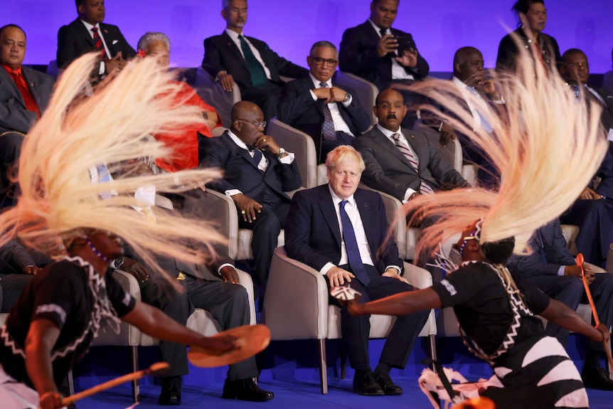 British Prime Minister Boris Johnson, centre, watches traditional dancers performing