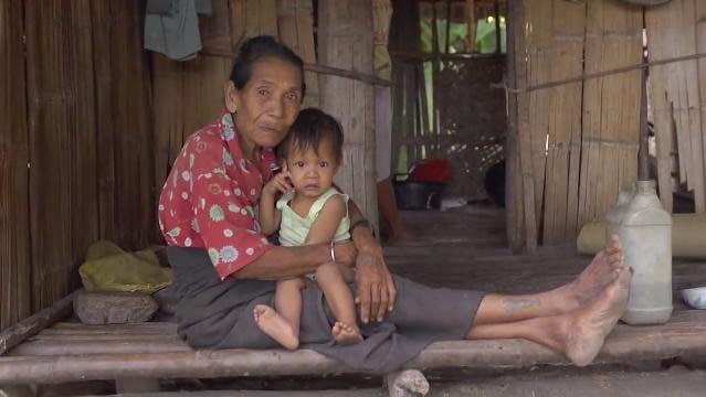 Indonesian woman sits with baby