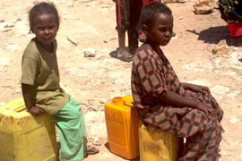 children waiting for water in a desert