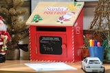 A red model postbox for children to send letters to Santa in a refuge.