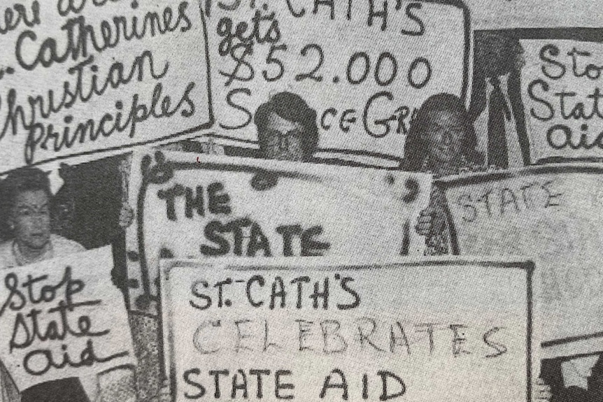 A black and white photo of protesters holding signs.