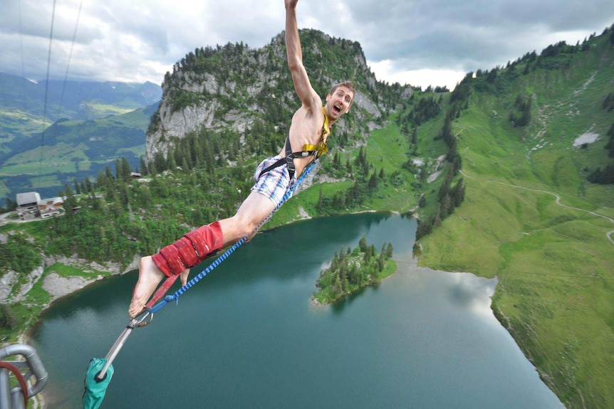 A man bungee jumps over a lake in Interlaken, Switzerland.