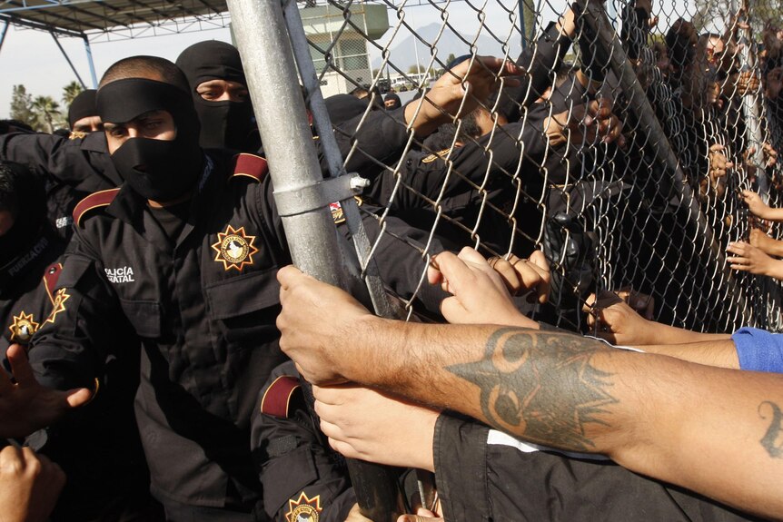 Relatives of inmates at Apodaca prison in Mexico attempt to breach the security fence.