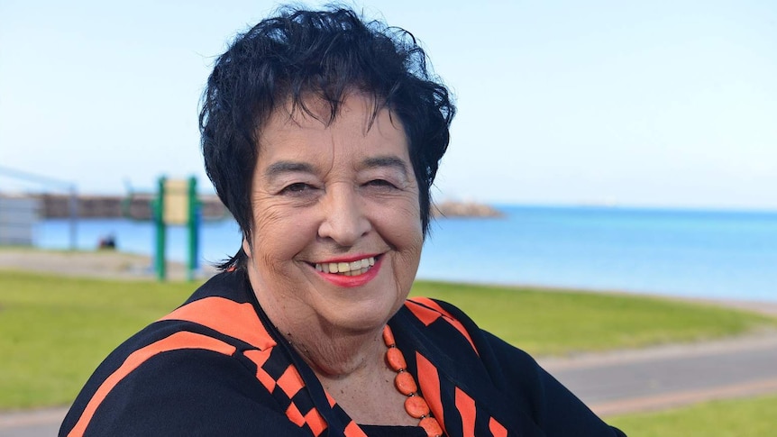 Woman sitting in front of the coastline of town