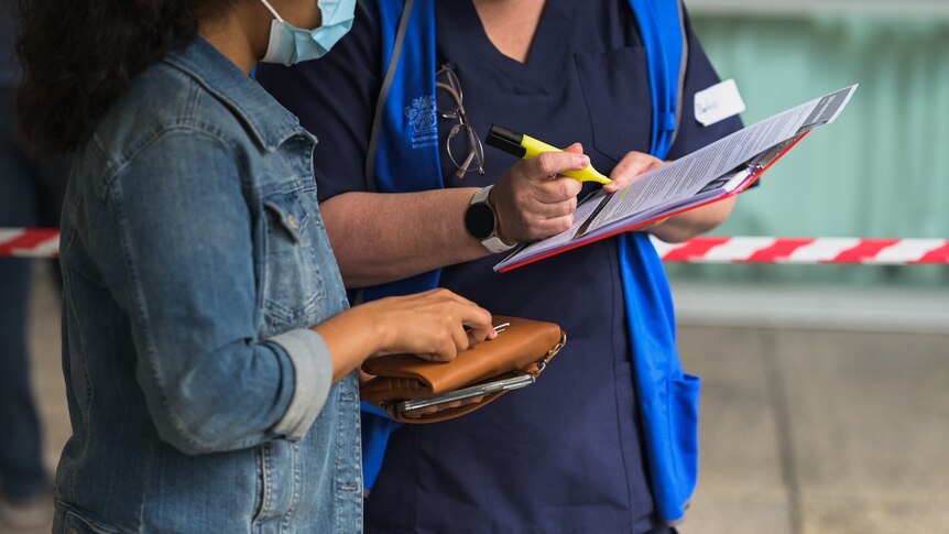 A woman gives her details at a vaccination clinic - good generic