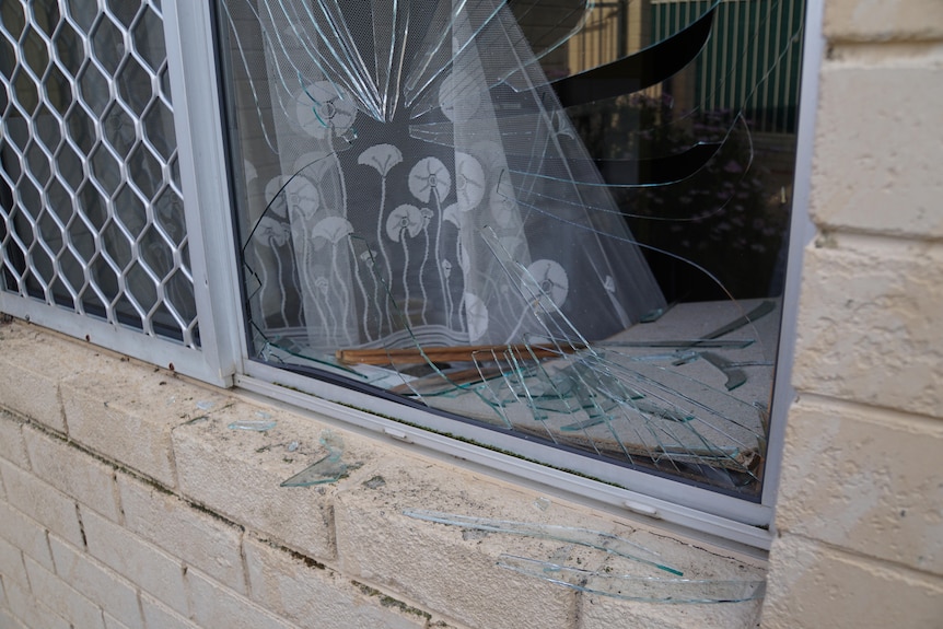 A close-up shot of a broken house window.