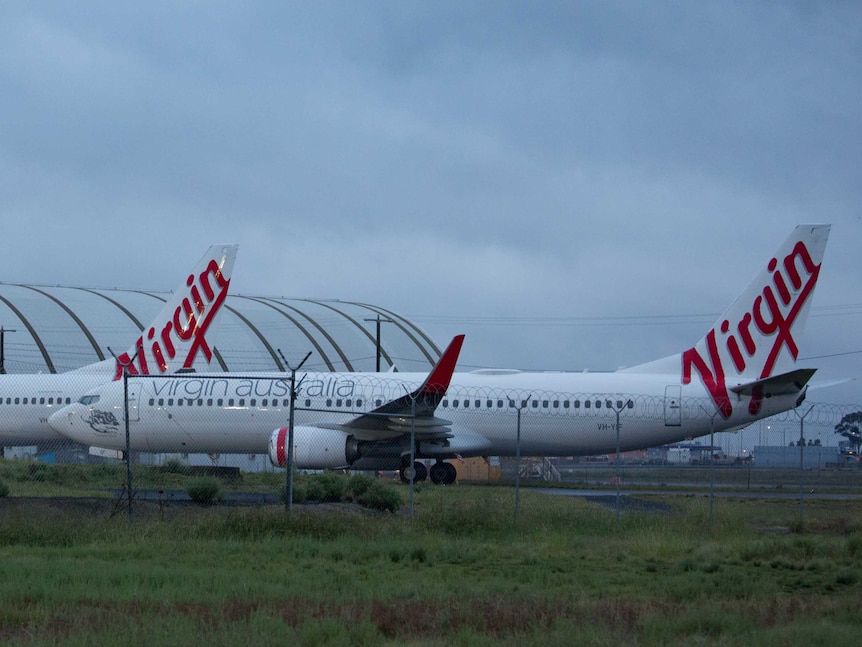 Two Virgin planes in front of a hangar