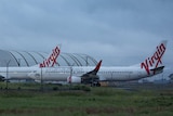 Two Virgin planes in front of a hangar