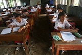 Indonesian elementary school students attend a class in an unfinished class room.
