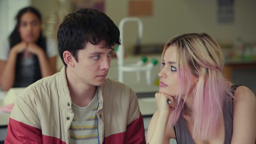 A teenage boy and girl stare into each other's eyes