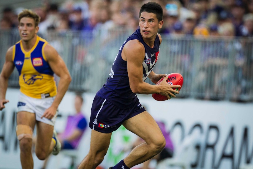 Fremantle Dockers tagger Bailey Banfield looks upfield while carrying the football against West Coast.