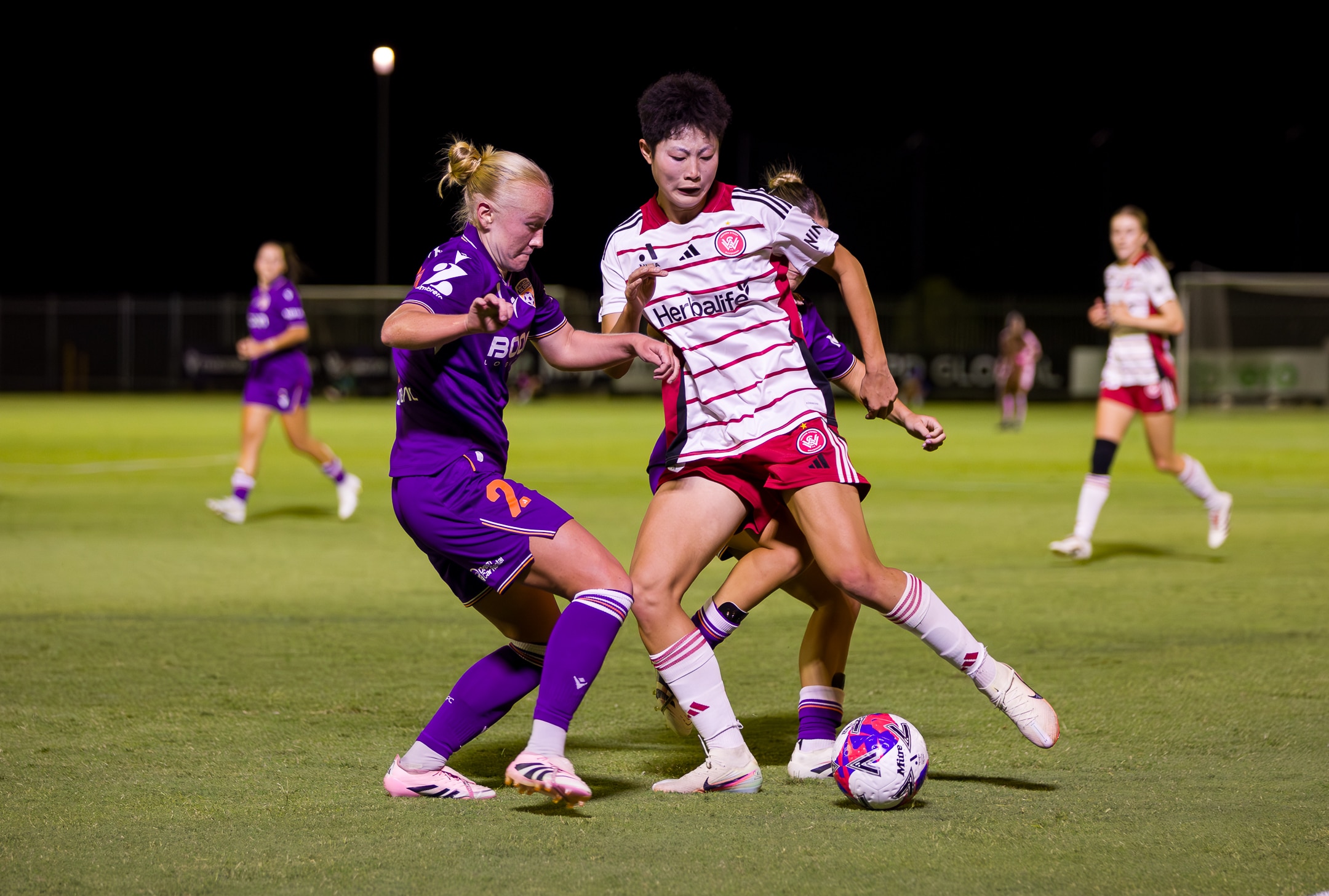 Jugadoras de fútbol persiguen la misma pelota durante un partido