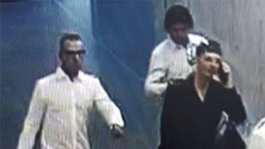 A CCTV screenshot of three men.