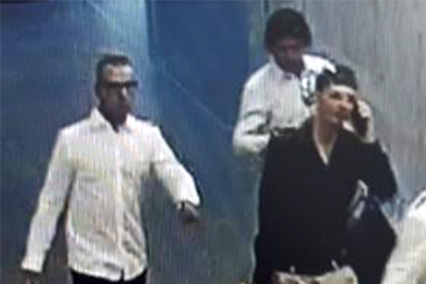 A CCTV screenshot of three men.