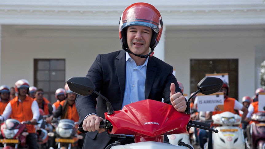 Uber CEO Travis Kalanick poses on a motorbike