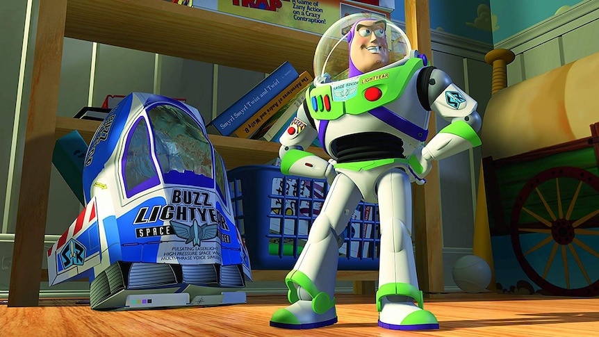 The astronaut character Buzz Lightyear stands proudly next to his toy ship in the Pixar film Toy Story.