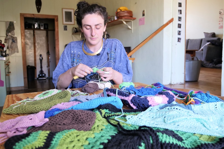 Alex Rosenblum crocheting at her kitchen table.