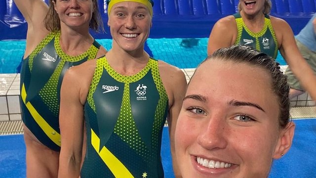 Tilly Kearns takes selfie with teammates in front of a pool in their bathers.
