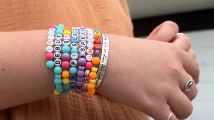 Close up of girl's hands with seven Taylor Swift-themed bead bracelets