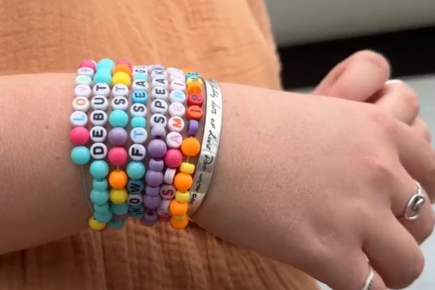 Close up of girl's hands with seven Taylor Swift-themed bead bracelets