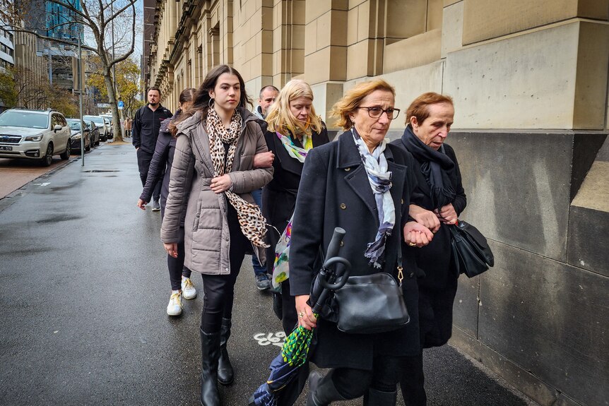 A group of people walks away from the Victorian Supreme Court