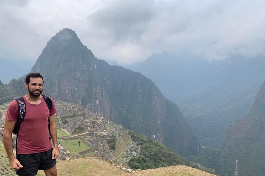 A man standing in front of a ruined south American city