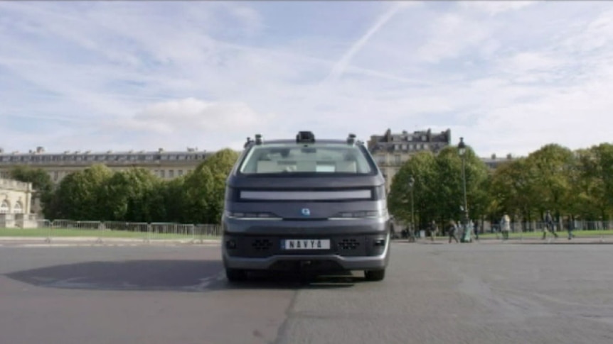A front-on view of a black driverless car travelling towards the camera.