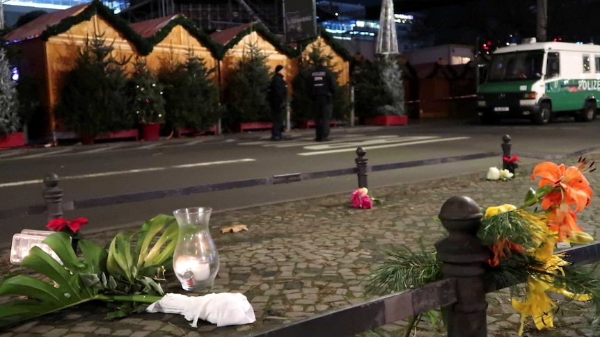 A candle and flowers are seen near the site where a truck ploughed through a crowd.