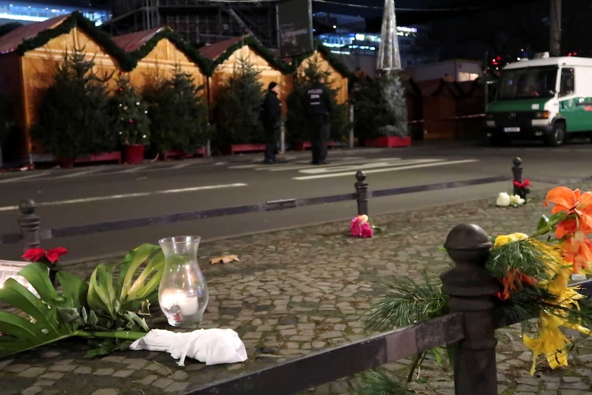 A candle and flowers are seen near the site where a truck ploughed through a crowd.