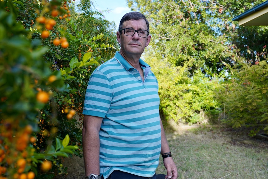 Man in striped shirt standing in garden