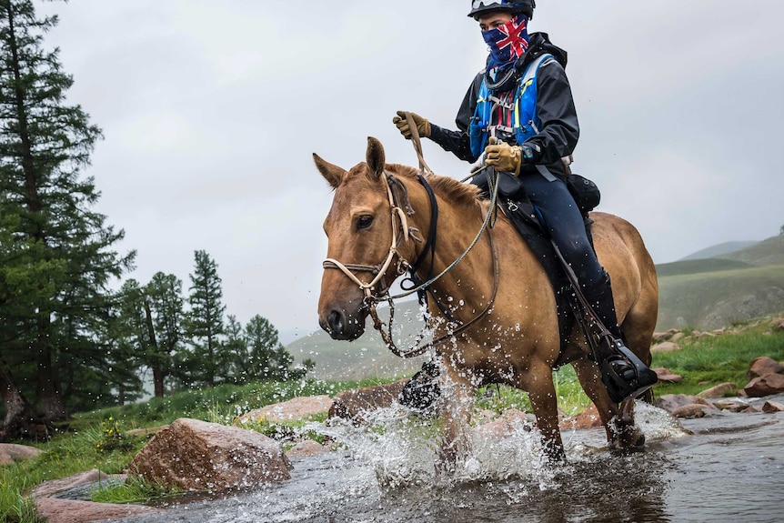 A rider crosses a stream during the Mongol Derby.