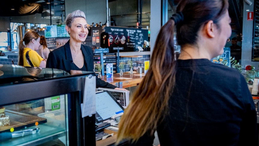 A woman behind the counter at a cafe.