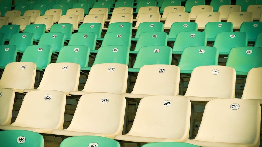 Rows of green and white stadium chairs.
