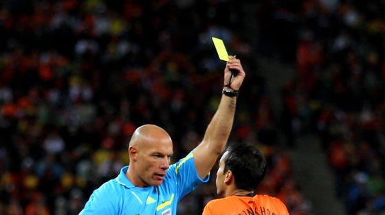 Referee Howard Webb issues the Netherlands' Giovanni Van Bronckhorst with a yellow card during the World Cup final.