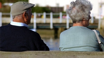 Two pensioners sit side by side on a park bench. (photoexpress.com)