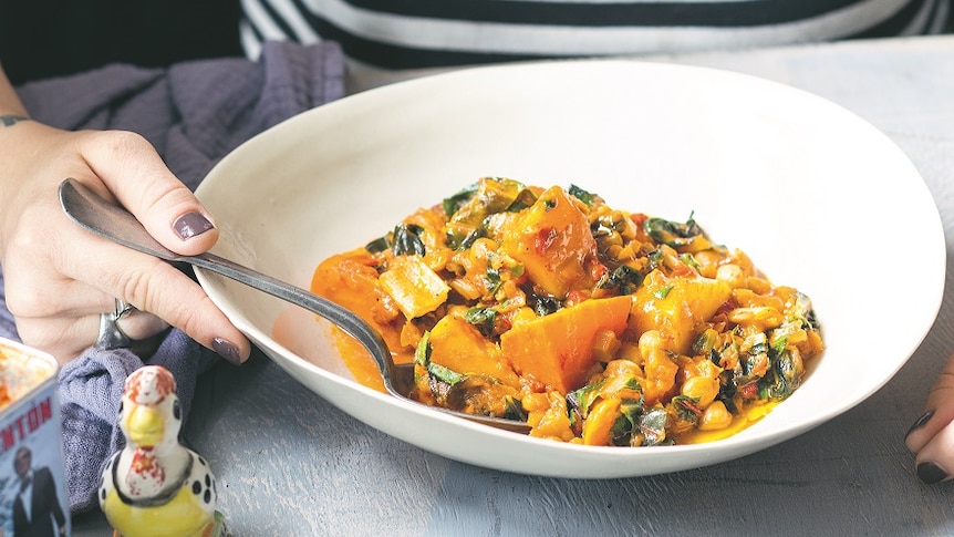 A vibrant orange stew in white dish.