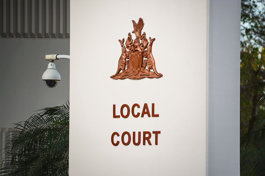 A security camera beside Darwin's Local Court entry sign.