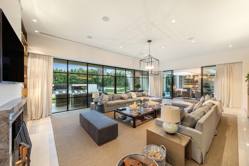 A large living space looking out to a lawn and swimming pool.